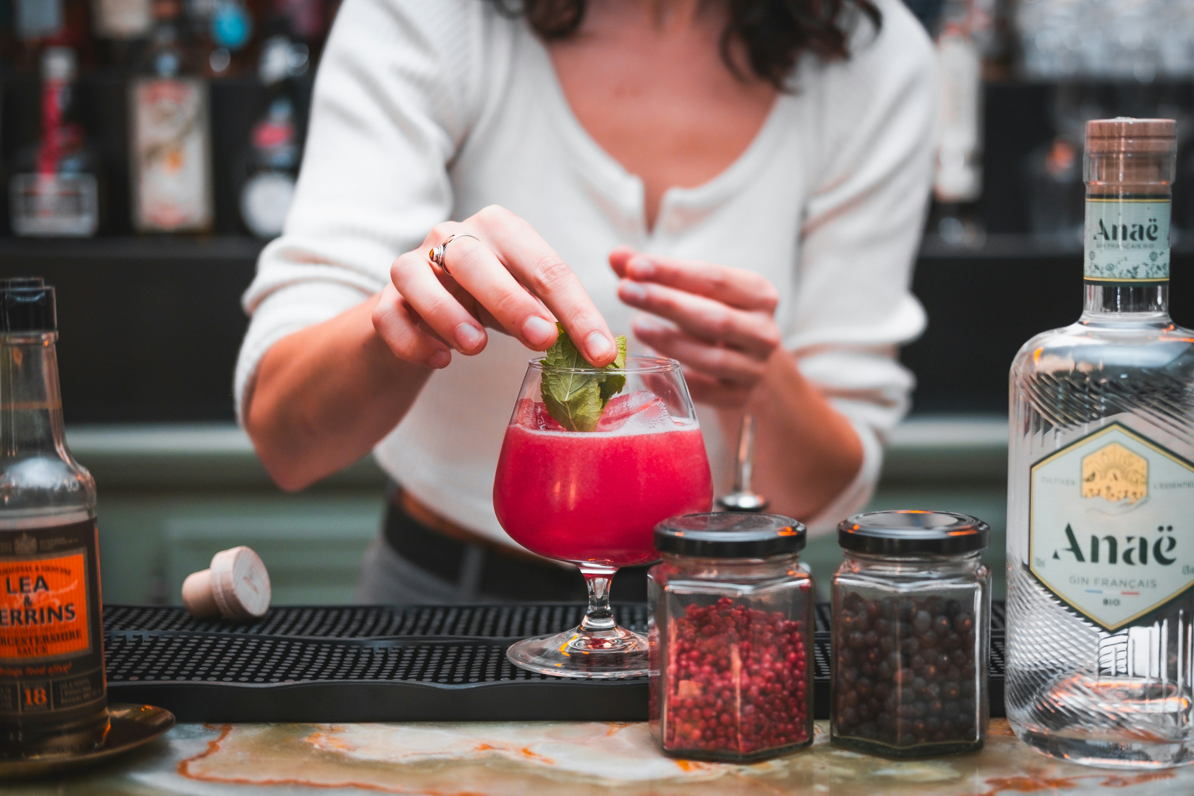 Cocktail being garnished with mint