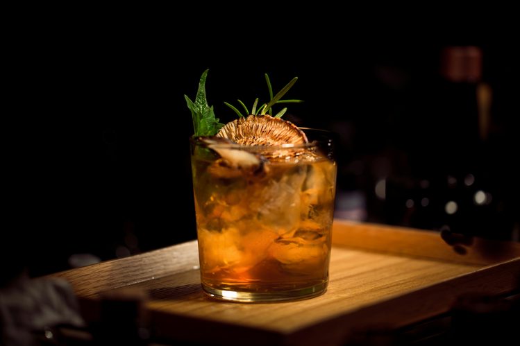 Smoked cocktail with fresh herb garnish