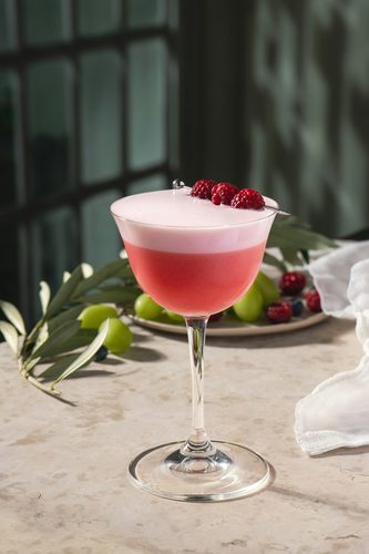 Woman laughing while holding a cocktail
