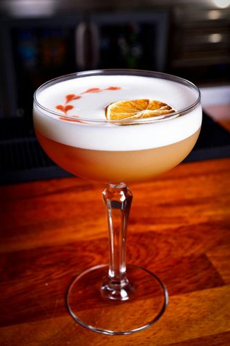 Bartender pouring a cocktail through a strainer