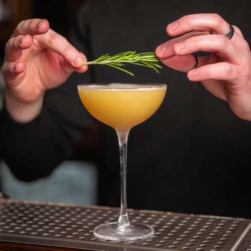 Rosemary garnish placed on a cocktail