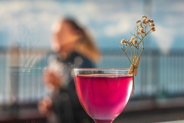 Pink cocktail with a dried flower garnish