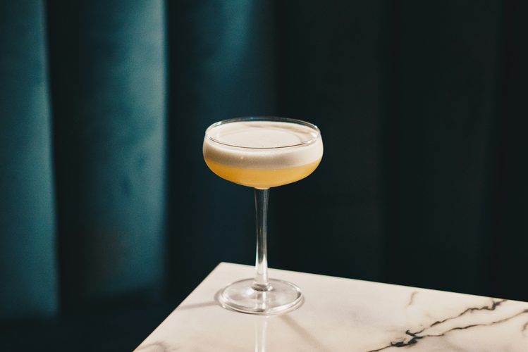 Frothy cocktail on a marble table