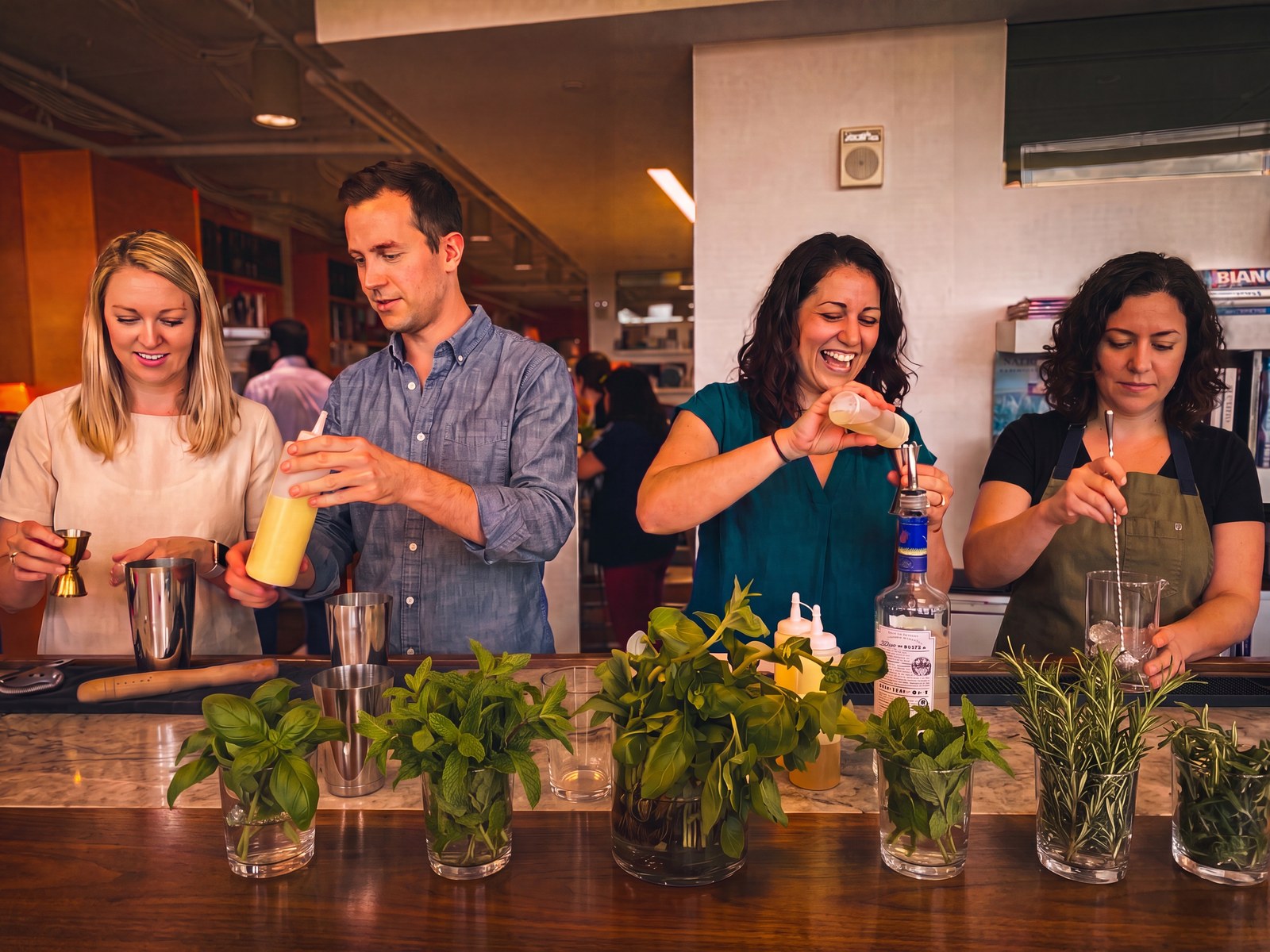 Coworkers working together to build cocktails at a bar